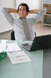 Portrait d'un homme en costume souriant assis à un bureau