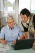 Portrait de deux hommes au bureau devant un ordinateur portable