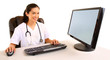 Photo: Smiling Nurse Sitting and Working at her Computer Smiling Nurse Sitting and Working at her Computer