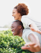 Man carrying his girlfriend on the back while outdoors