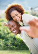 Smiling guy carrying his happy girlfriend on the back