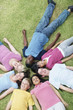 Happy young teens lying on grass head to head