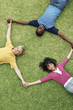 Top view three teenagers lying on grass and making a triangle