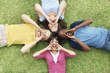 Shouting teenagers lying on grass in a circle
