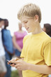 Happy teenage boy text messaging on mobile phone