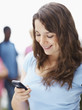 Happy teenage girl text messaging on the mobile phone
