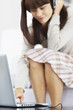 Woman using a laptop and headphones to listen to music