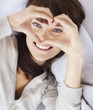 Smiling woman forming a heart with her hands