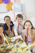 Young kids blowing party horns during a birthday party