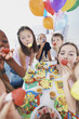 Young children enjoying a party with horn blowers
