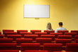 couple in empty conference hall. focus on third row