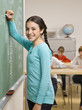Student writing on blackboard