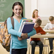 Student carrying backpack and books
