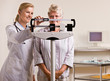 Doctor weighing senior woman in doctor office