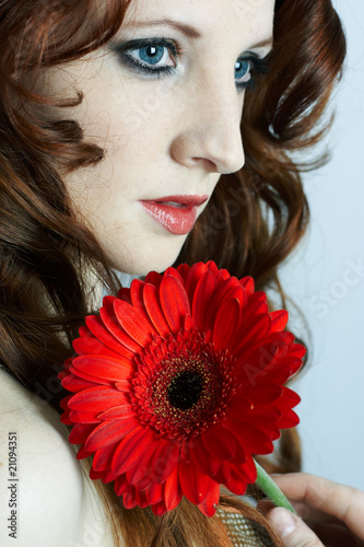 Photo: The beautiful young girl with a red flower The beautiful young girl with a red flower