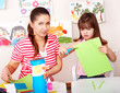 Child with scissors cut paper in play room.