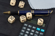 Photo: Calculator, pens, dice and financial concept Calculator, pens, dice and financial concept