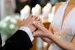 Bride putting a ring on groom's finger