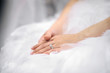 Bride's hands laying on wedding dress