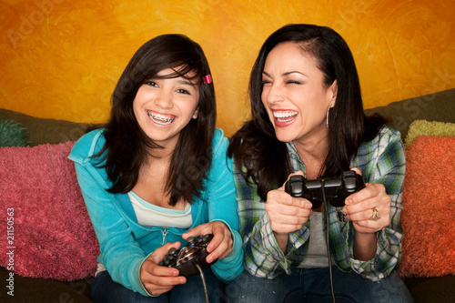 Photo: Hispanic Woman and Girl Playing Video game Hispanic Woman and Girl Playing Video game