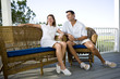 Photo: Happy mid-adult couple sitting together on terrace on vacation Happy mid-adult couple sitting together on terrace on vacation