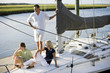 Photo: Father and two teenage children relaxing on boat Father and two teenage children relaxing on boat