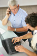 Portrait de deux hommes devant ordinateur portable au bureau