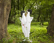 Two girls fencing in the forest.