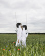 Two girls fencing in a field.