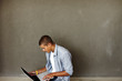 Handsome young man sitting on floor and using laptop Handsome young man sitting on floor and using laptop