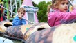 girl and boy row one after another in boats in park attraction