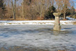 Kleiner gefrorener Teich mit Steinsäule rechts Kleiner gefrorener Teich mit Steinsäule rechts