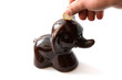 Putting the coin to a porcelain elephant money-box
