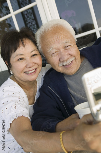 Photo: couple using mobile phone outdoors couple using mobile phone outdoors