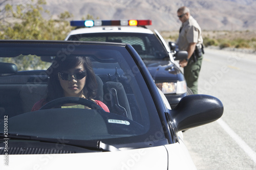 Photo: women sitting in car being pulled over by police officer women sitting in car being pulled over by police officer