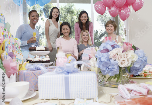 Photo: woman sitting at baby shower behind table of gifts woman sitting at baby shower behind table of gifts