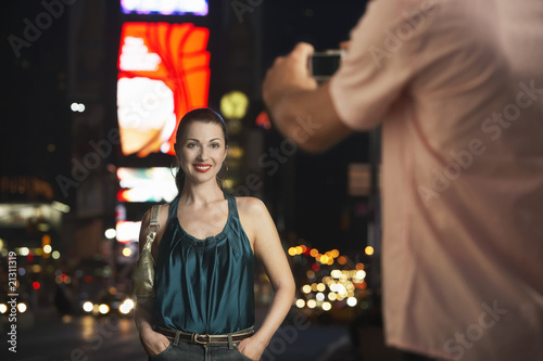 Photo: man photographing elegant woman in times square at night man photographing elegant woman in times square at night