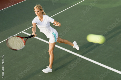 Photo: tennis player hitting tennis ball with forehand tennis player hitting tennis ball with forehand