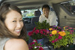 couple loading flowers into back of suv portrait