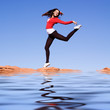 Young athletic woman jumping on the rocks