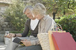 Photo: Man and woman sitting on wall with shopping bags Man and woman sitting on wall with shopping bags