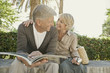 Photo: Man and woman sitting on wall with guidebook Man and woman sitting on wall with guidebook
