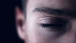 Closeup of young male eye against dark background