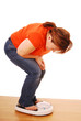 Woman looking hopeful at bathroom scales