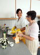 Pflegerin mit Seniorin beim Abwasch