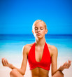 Woman doing yoga moves or meditating on beach