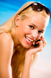 Happy woman with cell phone on beach