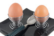 two eggs and spoon on plate on white background