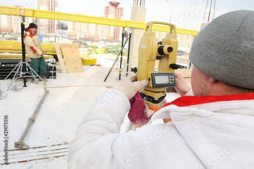 Photo: surveyor worker and theodolite at construction site surveyor worker and theodolite at construction site