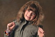 Ein kleines Mädchen posiert im Winterjacke. Fotostudio.